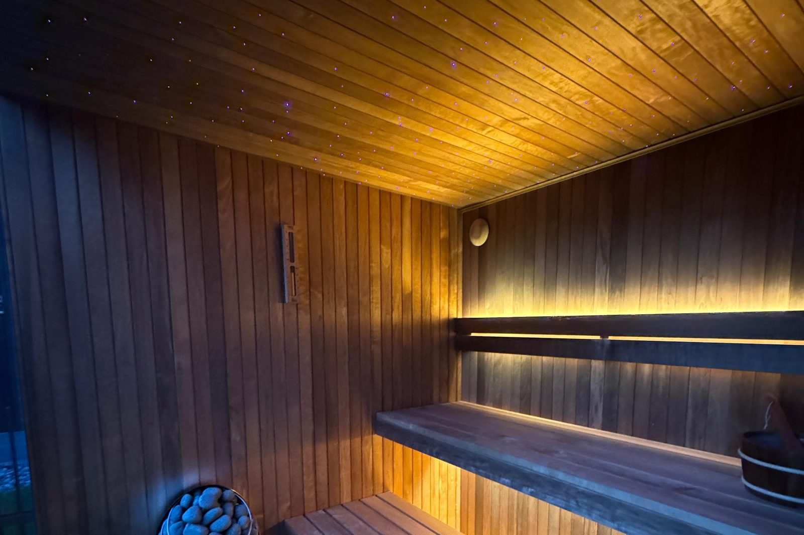 NORD Cube interior at night — starlight ceiling and LED lighting beneath floating thermo aspen benches